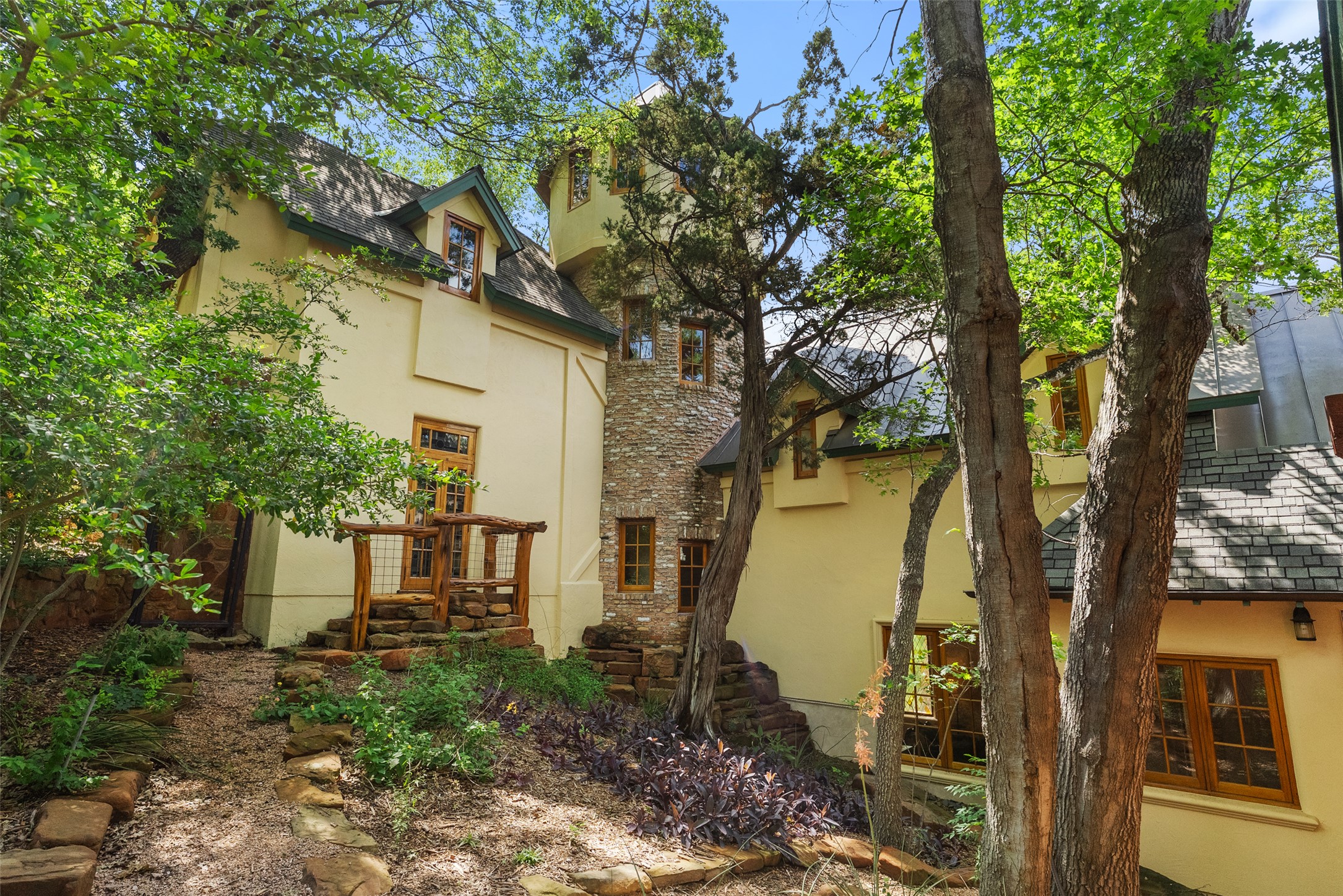 1354 The High Road Austin, TX 78746 - Photo 39 of 40 A captivating, castle-inspired residence nestled among mature trees, showcasing unique architecture and natural surroundings.