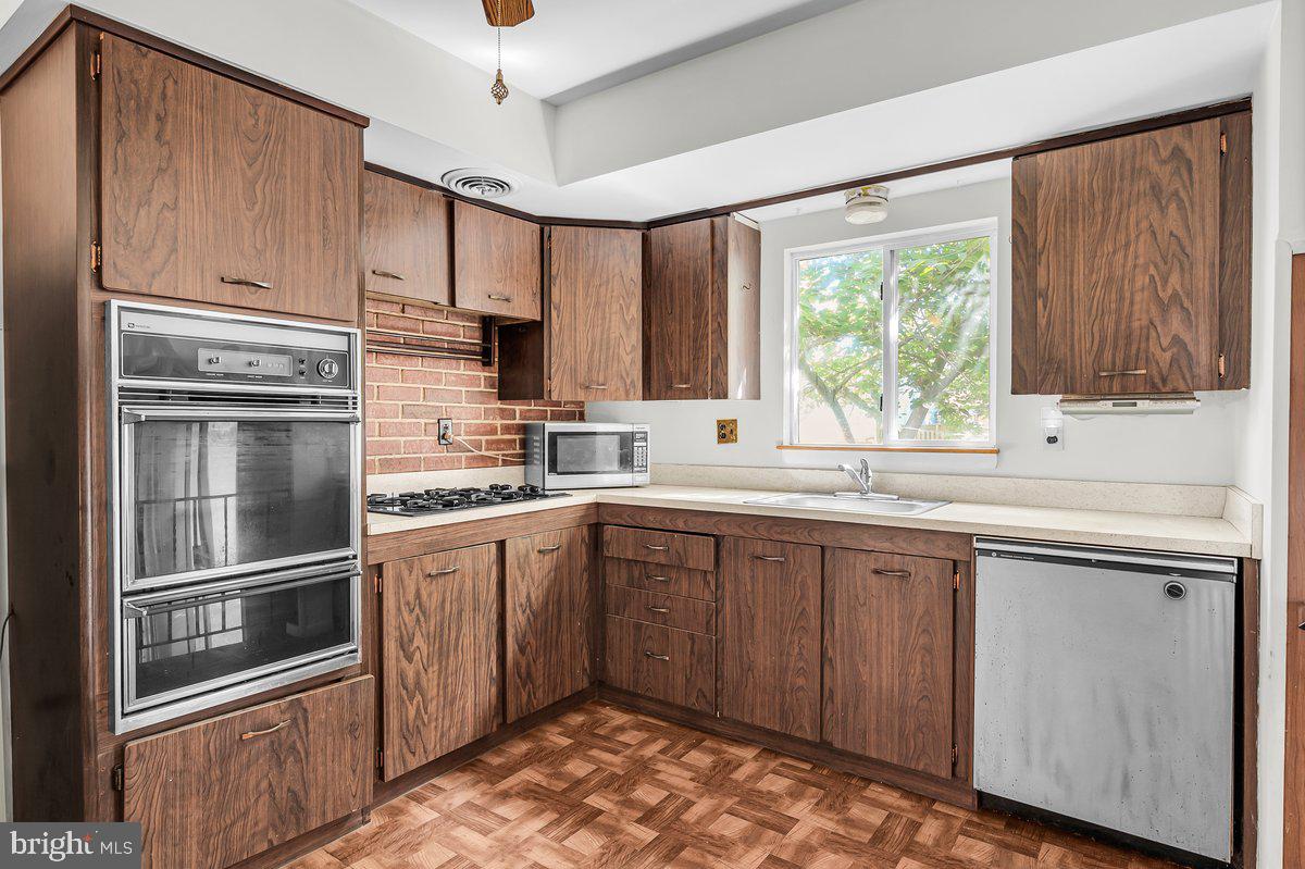 1216 Grayrock Road Newark, DE 19713 - Photo 10 of 28 a kitchen with granite countertop stainless steel appliances a sink cabinets and a window