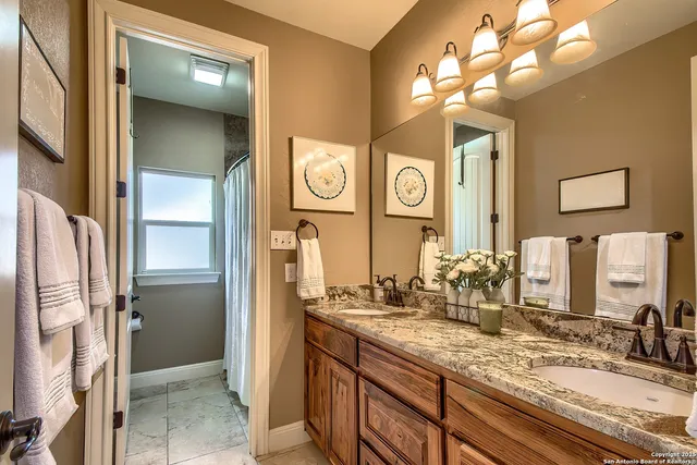 a bathroom with a granite countertop sink and a mirror
