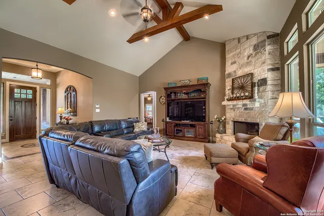 a living room with furniture a fireplace and a large window