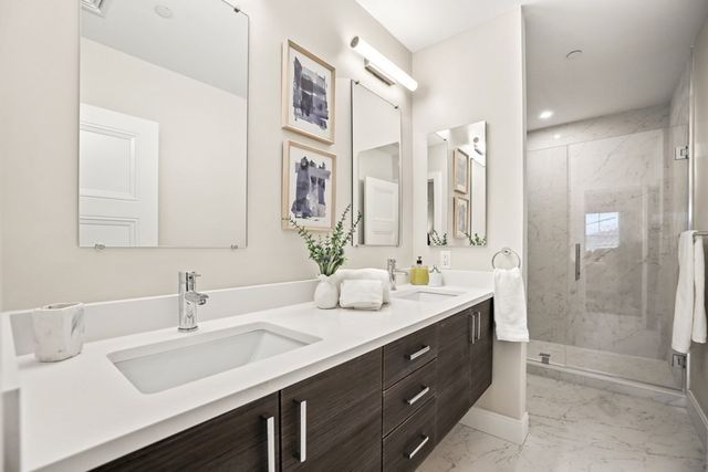 a bathroom with a double vanity sink mirror and shower