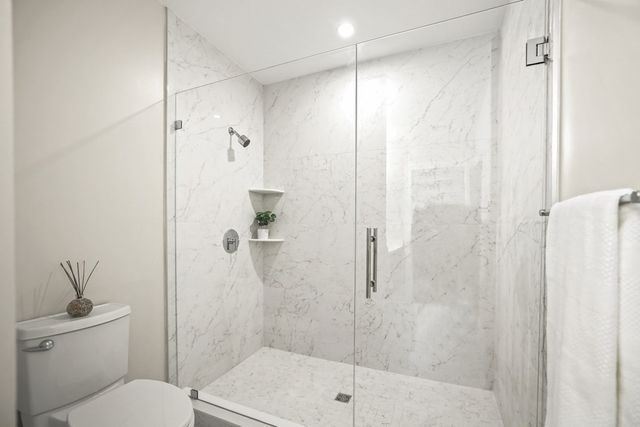 a bathroom with a shower a toilet and a sink