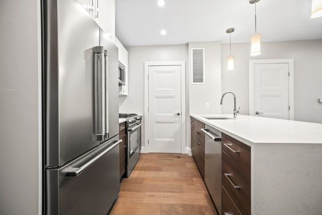 a kitchen with a refrigerator a sink and cabinets