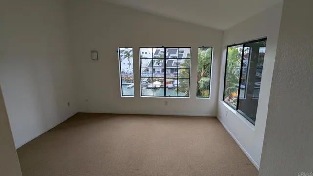 an empty room with windows and fan