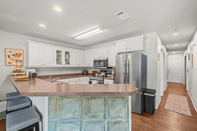 a kitchen with kitchen island a counter top space appliances and a refrigerator
