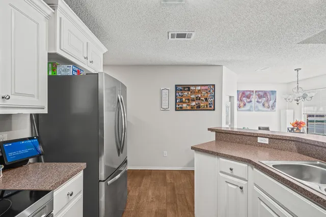 a kitchen with stainless steel appliances granite countertop a refrigerator and a sink