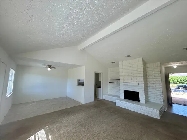 an empty room with fireplace and windows