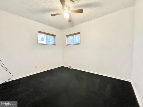 an empty room with a ceiling fan and a window