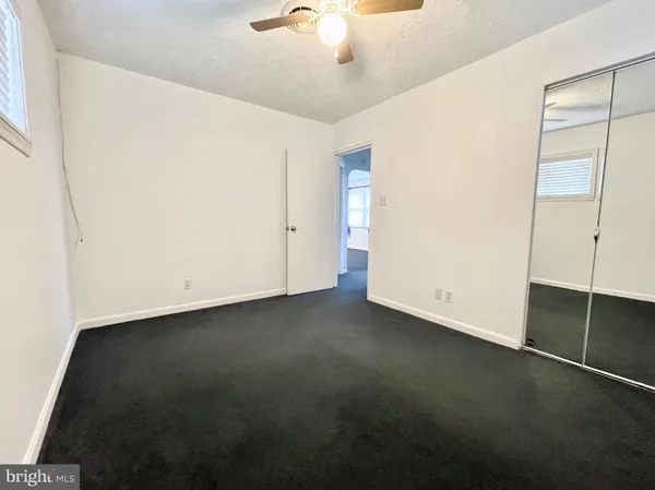 an empty room with a ceiling fan and a window