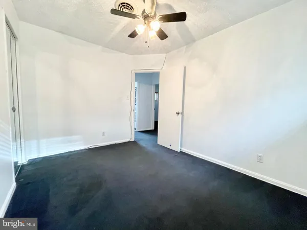 an empty room with a ceiling fan and painted walls