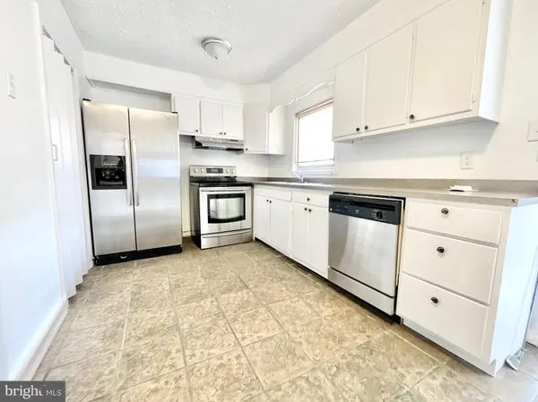 a kitchen with cabinets stainless steel appliances and a window