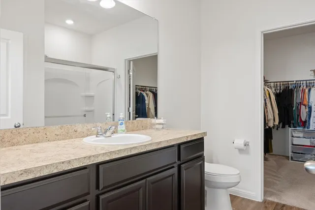 a bathroom with a granite countertop sink a toilet and a mirror