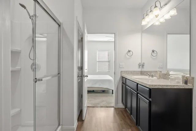 a en suite bathroom with a granite countertop sink a toilet and a mirror