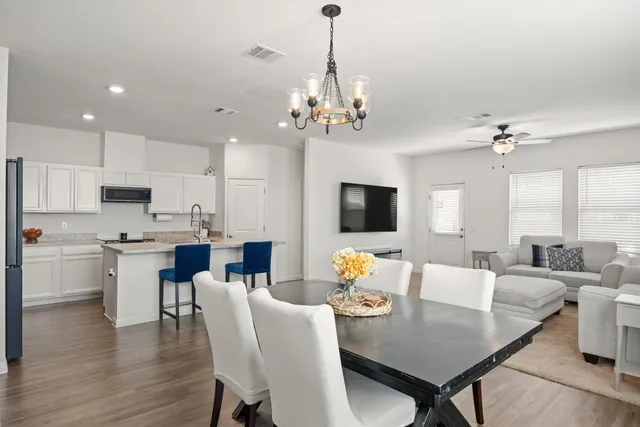 a view of a dining room with furniture a chandelier and wooden floor