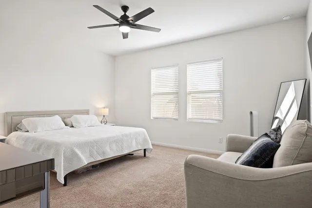 a bedroom with a bed couches and window