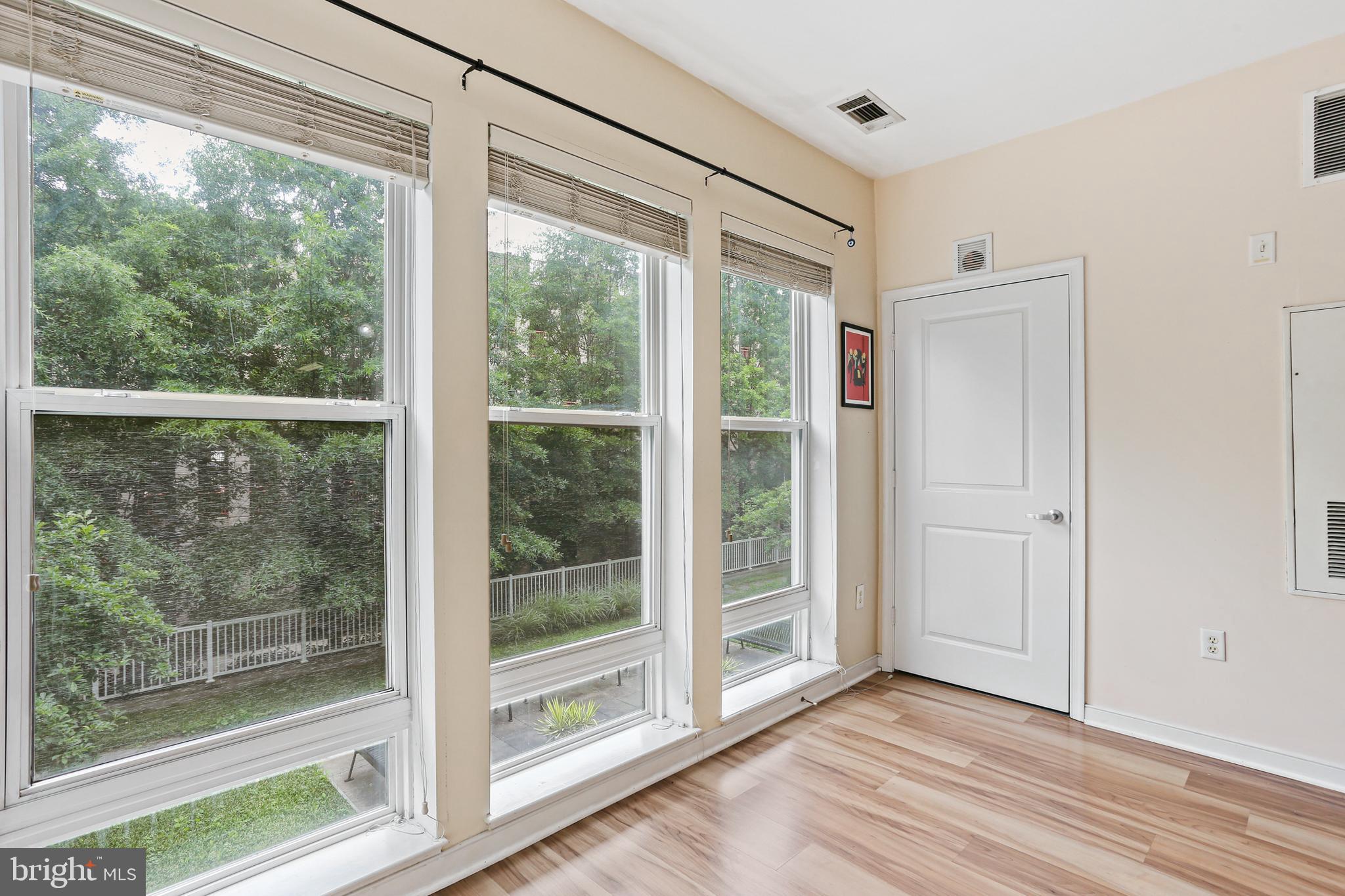 8045 Newell Street, Unit 223 Silver Spring, MD 20910 - Photo 10 of 25 Sunroom overlooking courtyard with tree line