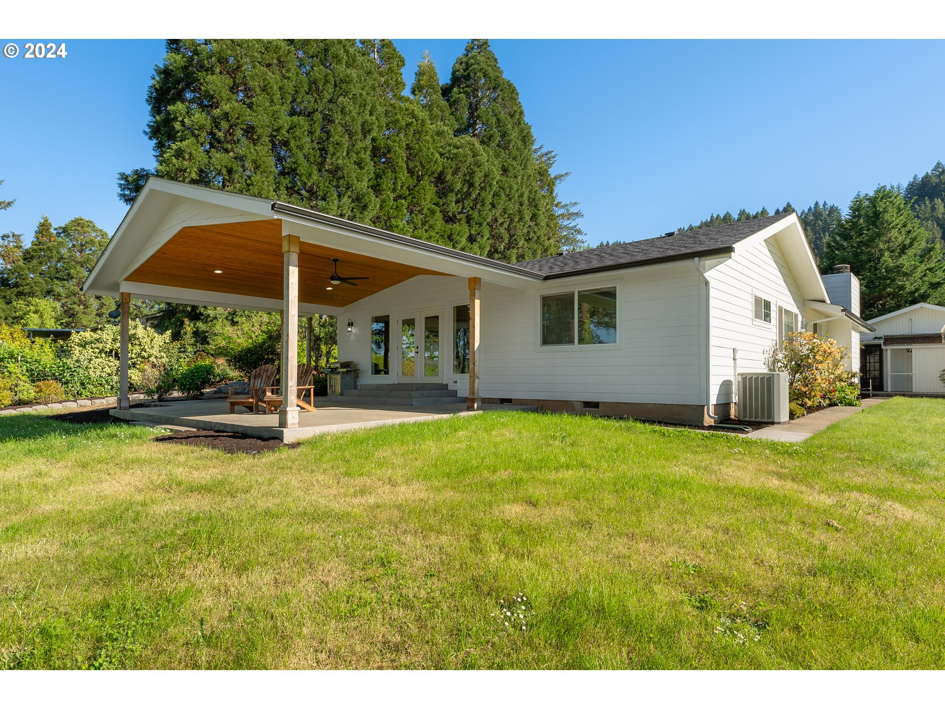 3993 Melqua Road Roseburg, OR 97471 - Photo 6 of 48 a backyard of a house with table and chairs under an umbrella