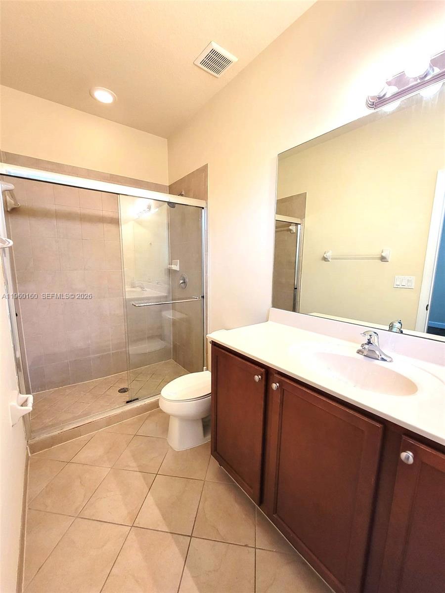 9031 Southwest 227th Street, Unit 5 Cutler Bay, FL 33190 - Photo 17 of 21 a bathroom with a double vanity sink toilet and shower