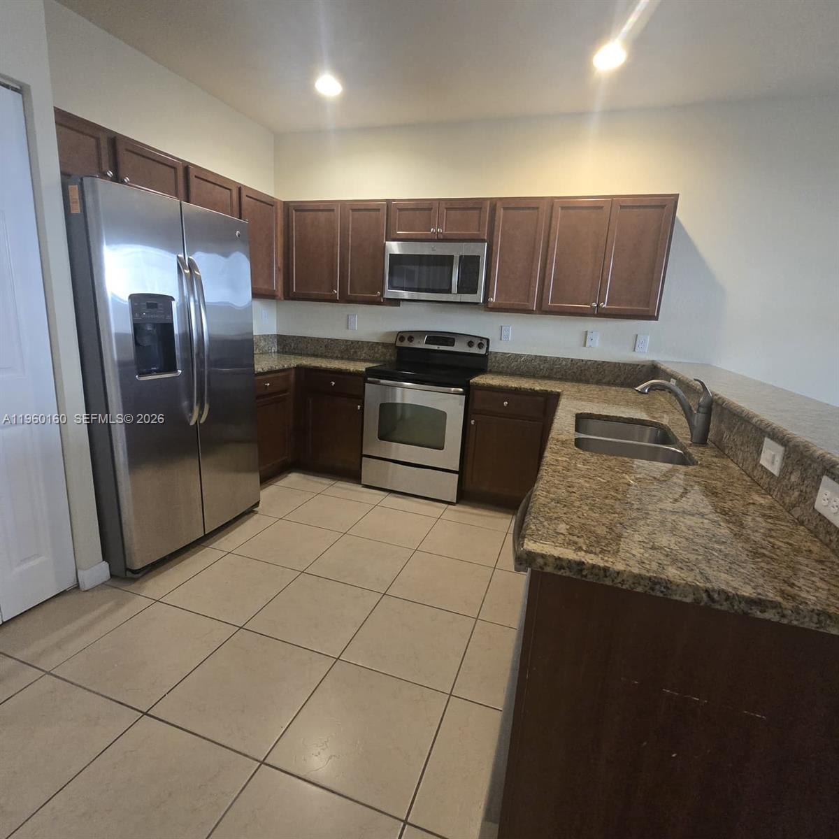 9031 Southwest 227th Street, Unit 5 Cutler Bay, FL 33190 - Photo 9 of 21 a kitchen with stainless steel appliances granite countertop a sink stove and refrigerator