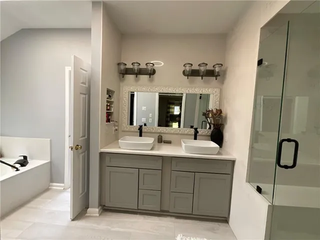 a en suite bathroom with a double vanity sink and mirror