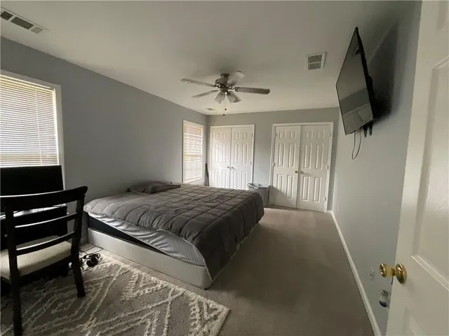 a bedroom with a bed and a flat tv screen on a dresser