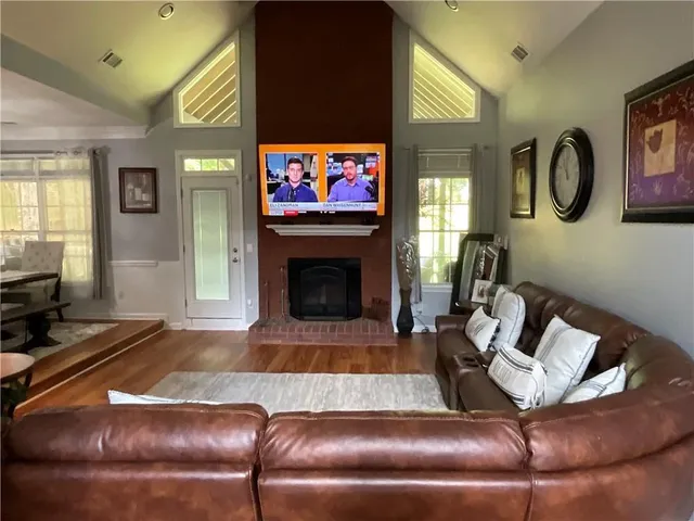 a living room with furniture a flat screen tv and a fireplace