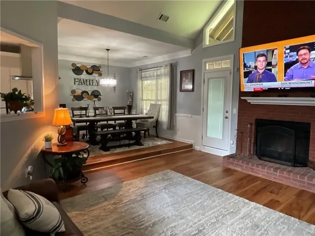 a living room with furniture a flat screen tv and a fireplace