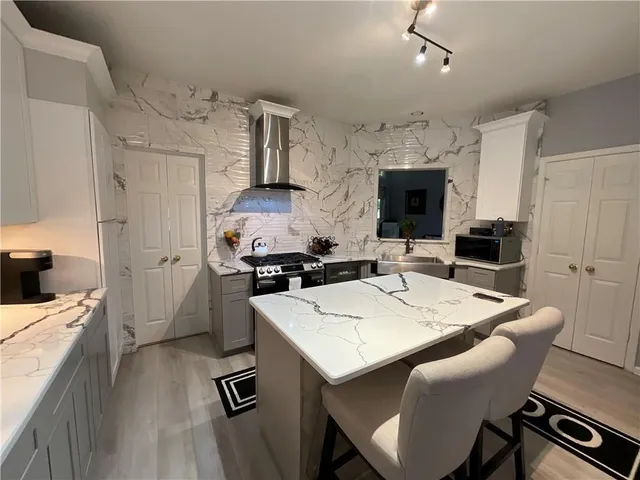 a kitchen with a sink a stove and chairs