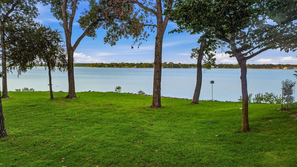7250 Briar Road Azle, TX 76020 - Photo 38 of 40 Expansive waterfront property featuring a manicured lawn, mature trees, and direct access to the lake