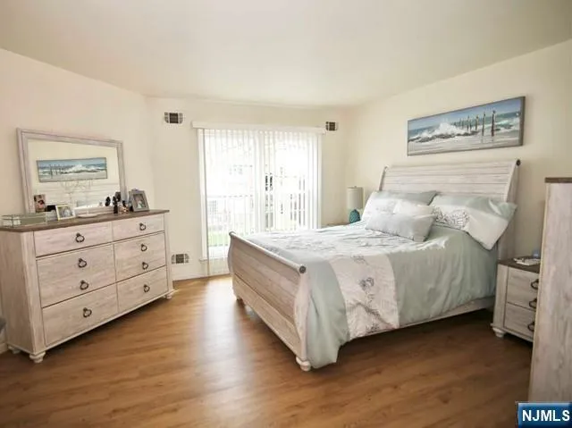 a spacious bedroom with a bed and a dresser in it