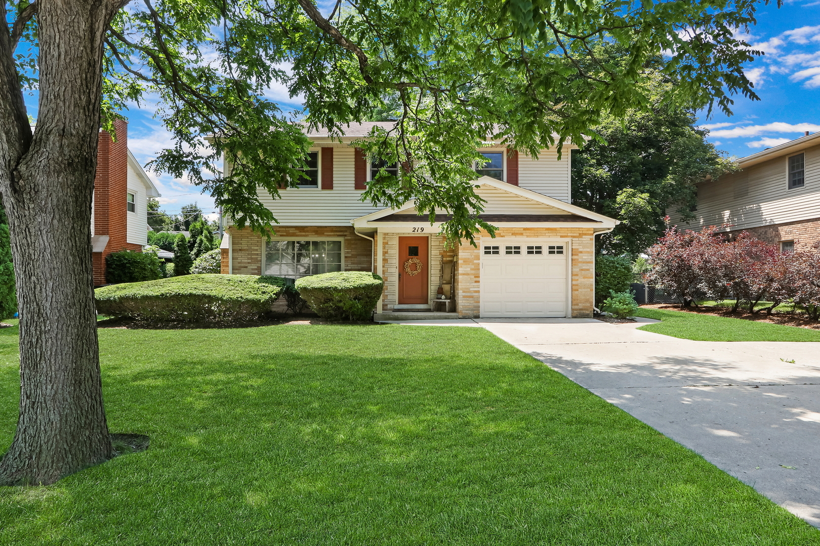 219 East Rockland Road Libertyville, IL 60048 - Photo 1 of 23 a front view of a house with a garden and trees