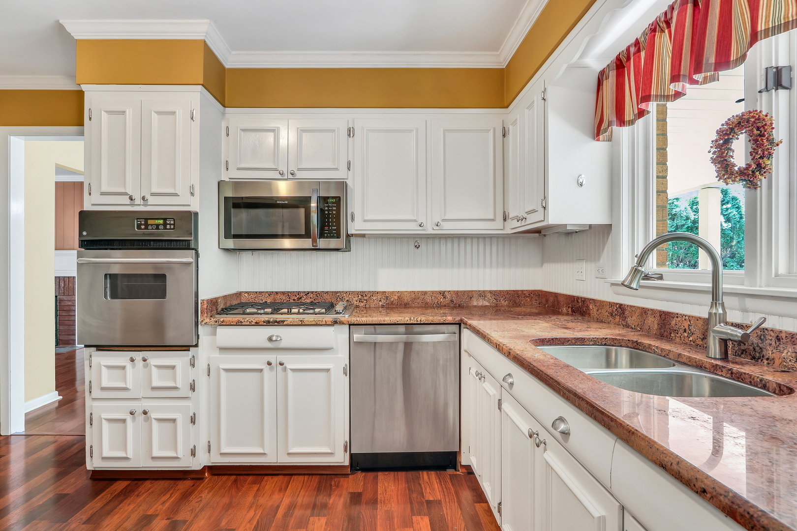 219 East Rockland Road Libertyville, IL 60048 - Photo 10 of 23 a kitchen with stainless steel appliances granite countertop a sink a stove and a microwave oven with white cabinets