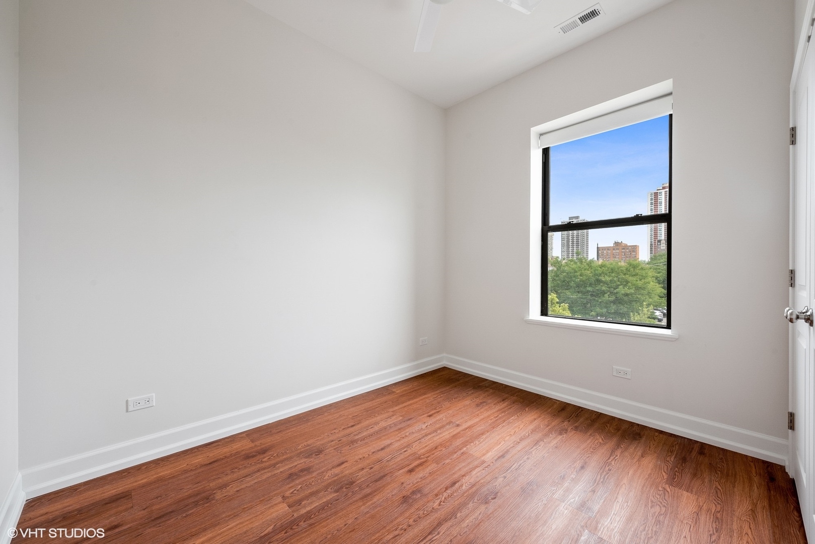 6036 North Broadway, Unit 3 Chicago, IL 60660 - Photo 11 of 17 an empty room with wooden floor and windows