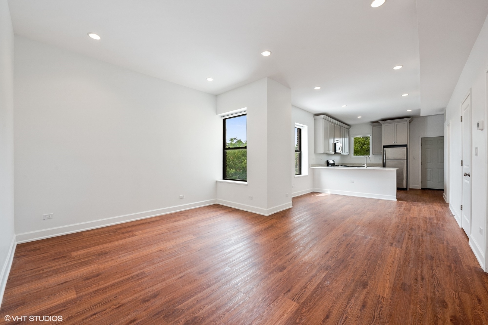 6036 North Broadway, Unit 3 Chicago, IL 60660 - Photo 3 of 17 a view of a kitchen and an empty room with wooden floor