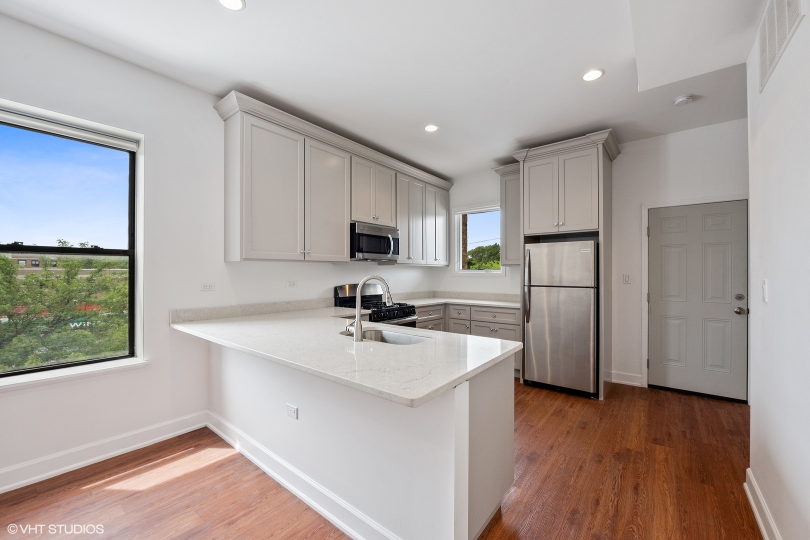 6036 North Broadway, Unit 3 Chicago, IL 60660 - Photo 6 of 17 a kitchen with a refrigerator a sink and wooden floor