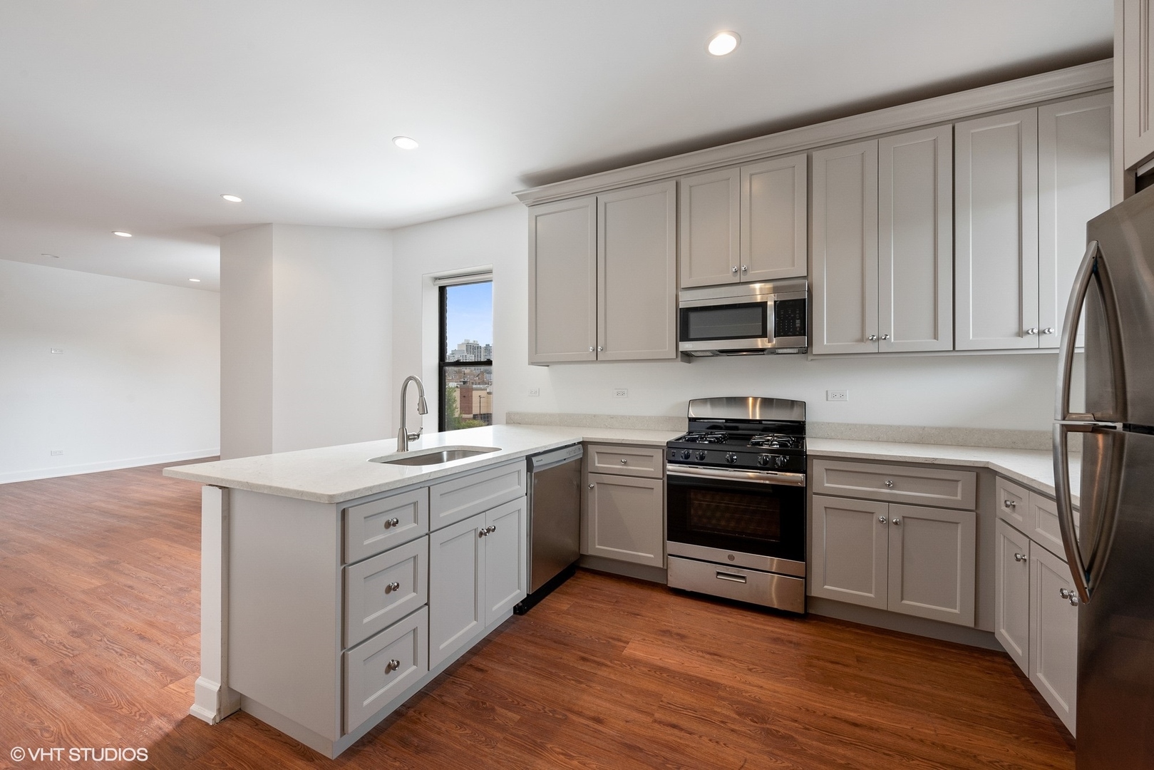 6036 North Broadway, Unit 3 Chicago, IL 60660 - Photo 8 of 17 a kitchen with stainless steel appliances granite countertop a stove a sink and a microwave