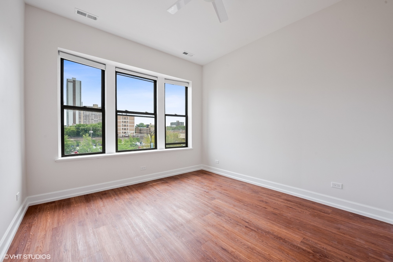 6036 North Broadway, Unit 3 Chicago, IL 60660 - Photo 9 of 17 an empty room with wooden floor and windows