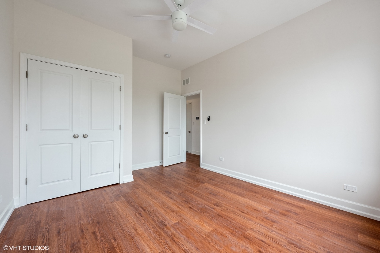 6036 North Broadway, Unit 3 Chicago, IL 60660 - Photo 10 of 17 a view of a room with wooden floor and a ceiling fan