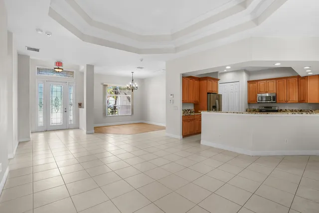 a view of a kitchen with kitchen island granite countertop a refrigerator and a sink