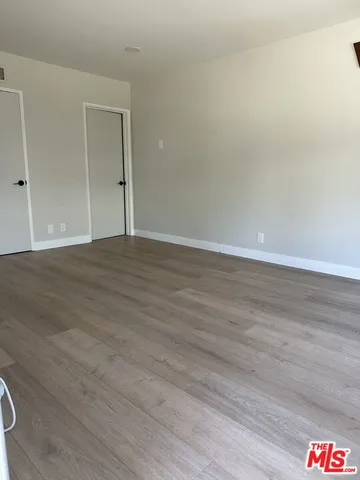 a view of an empty room and wooden floor