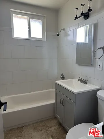a bathroom with a sink toilet vanity and bathtub