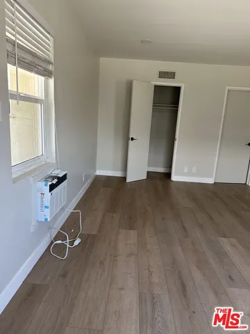 a view of a room with wooden floor and cabinet