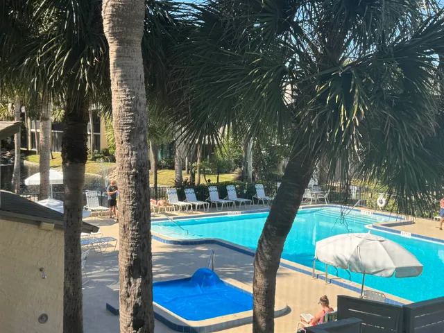 a view of a swimming pool with a patio and fire pit