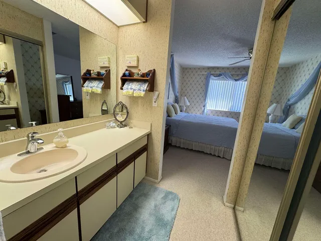 a en suite bathroom with a granite countertop sink and a mirror