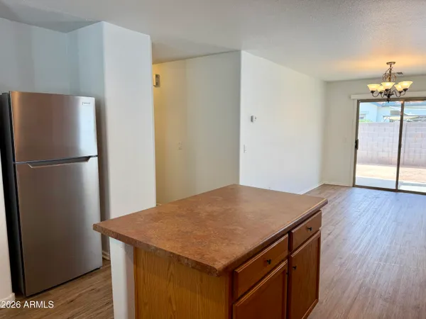 a kitchen with a refrigerator a stove and wooden floor