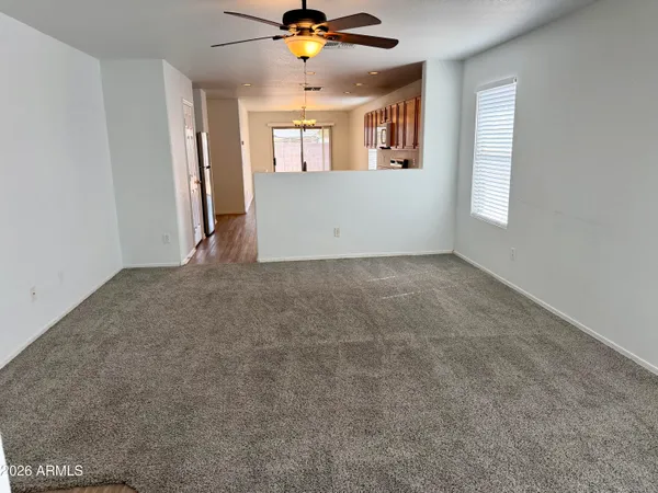 an empty room with windows and ceiling fan