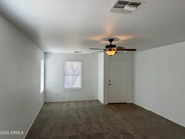 an empty room with windows and cabinet