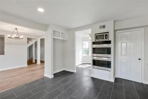 a view of a kitchen with wooden floor and electronic appliances