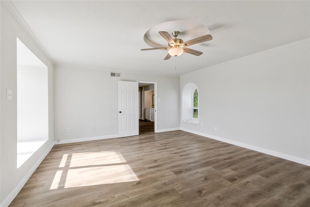 41 Kelsey Road Denison, TX 75021 - Photo 17 of 31 Alternate view of primary bedroom featuring a walk-in closet, ceiling fan, and new luxury vinyl plank flooring.