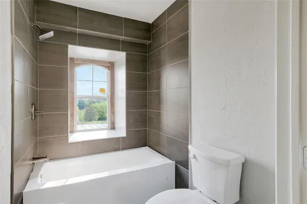 a bathroom with a bathtub and window